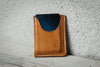 Brown leather wallet with blue interior on a textured surface