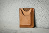 Brown leather cardholder on a textured gray surface
