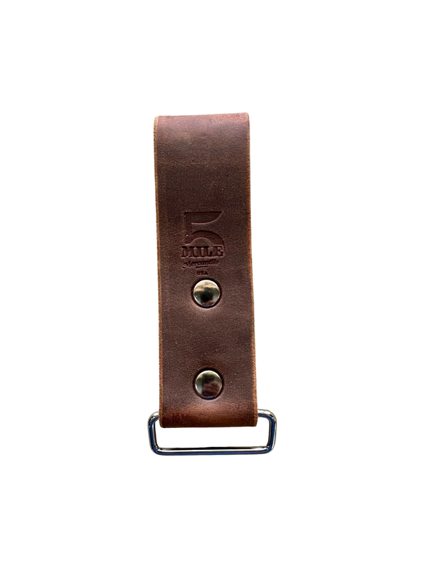 Brown leather strap with metal buckle on a white background