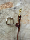 Brown Leather Belt and silver buckle on a textured surface