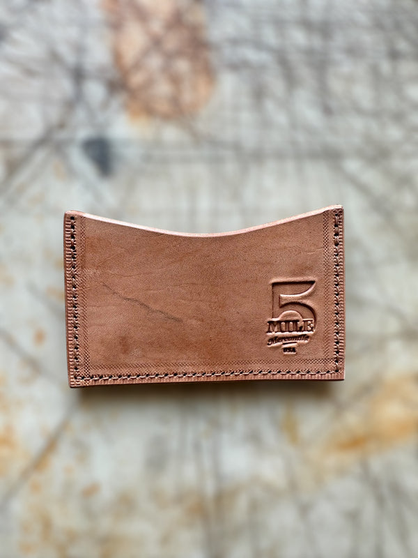 Brown leather wallet with '5' logo on a textured surface
