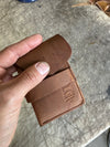 Pocket wallet with flap Brown flap partially closed on cutting table