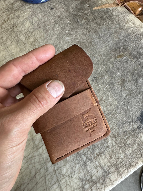Pocket wallet with flap Brown flap partially closed on cutting table