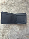 3 pocket bifold wallet black on cutting table