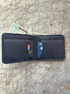 3 pocket bifold wallet black with cards and cash on cutting table