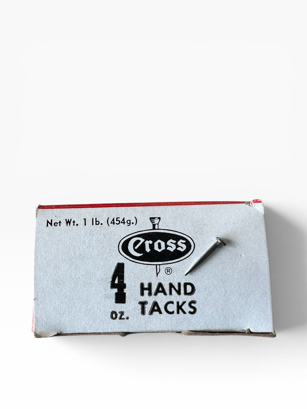 Box of Cross hand tacks on a white background