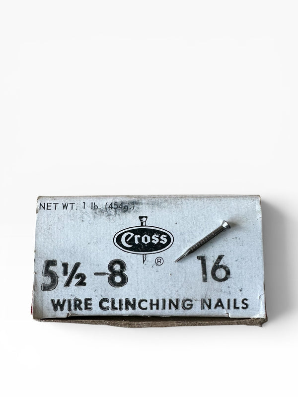 Box of wire clinching nails with a nail on a white background