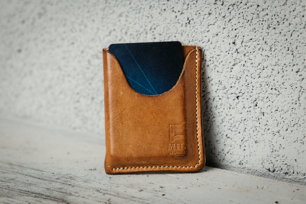Brown leather wallet with blue interior on a textured surface