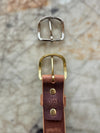 Gold and silver belt buckles on a textured surface