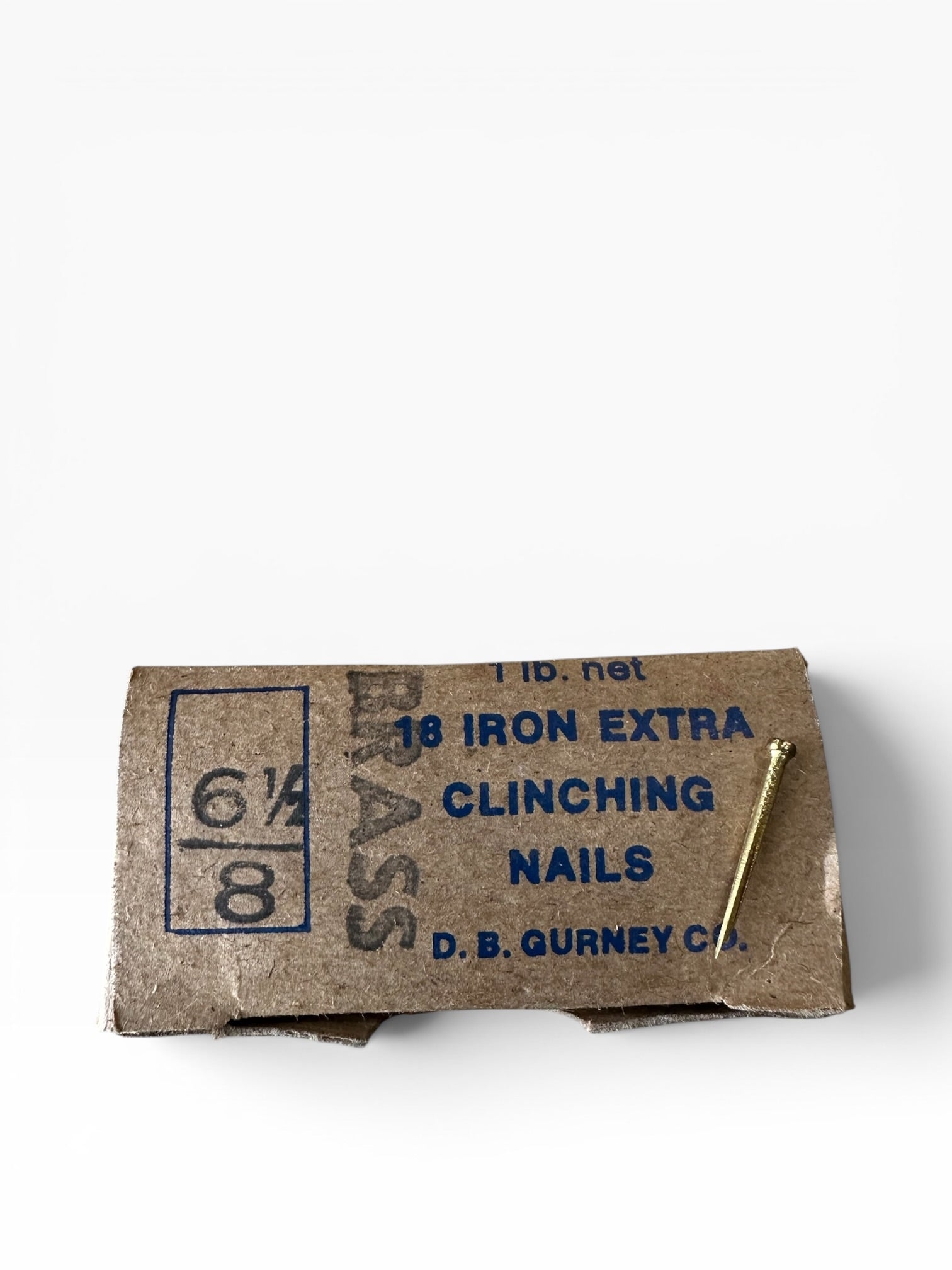 Cardboard box of iron nails with a nail sticking out on a white background