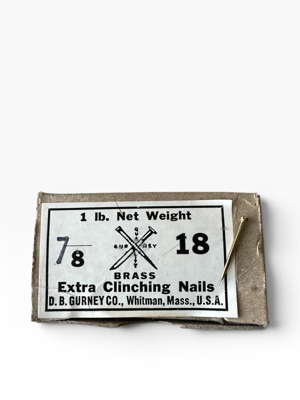 Box of brass nails with a label on a white background