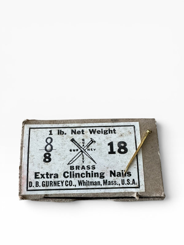Box of brass nails with a label on a white background