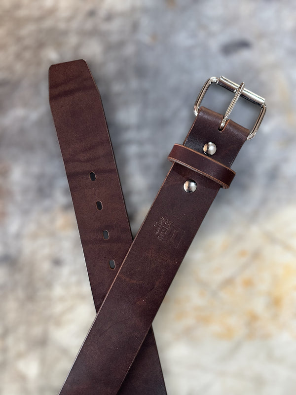 Brown belt with silver buckle on cutting table