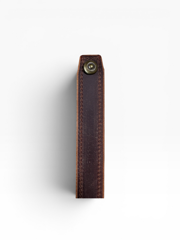 A close-up of a dark brown leather strap or belt section with visible stitching and a small brass-tone metal rivet near the top, shown against a plain white background.