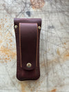 Back of Brown leather knife sheath on a textured surface