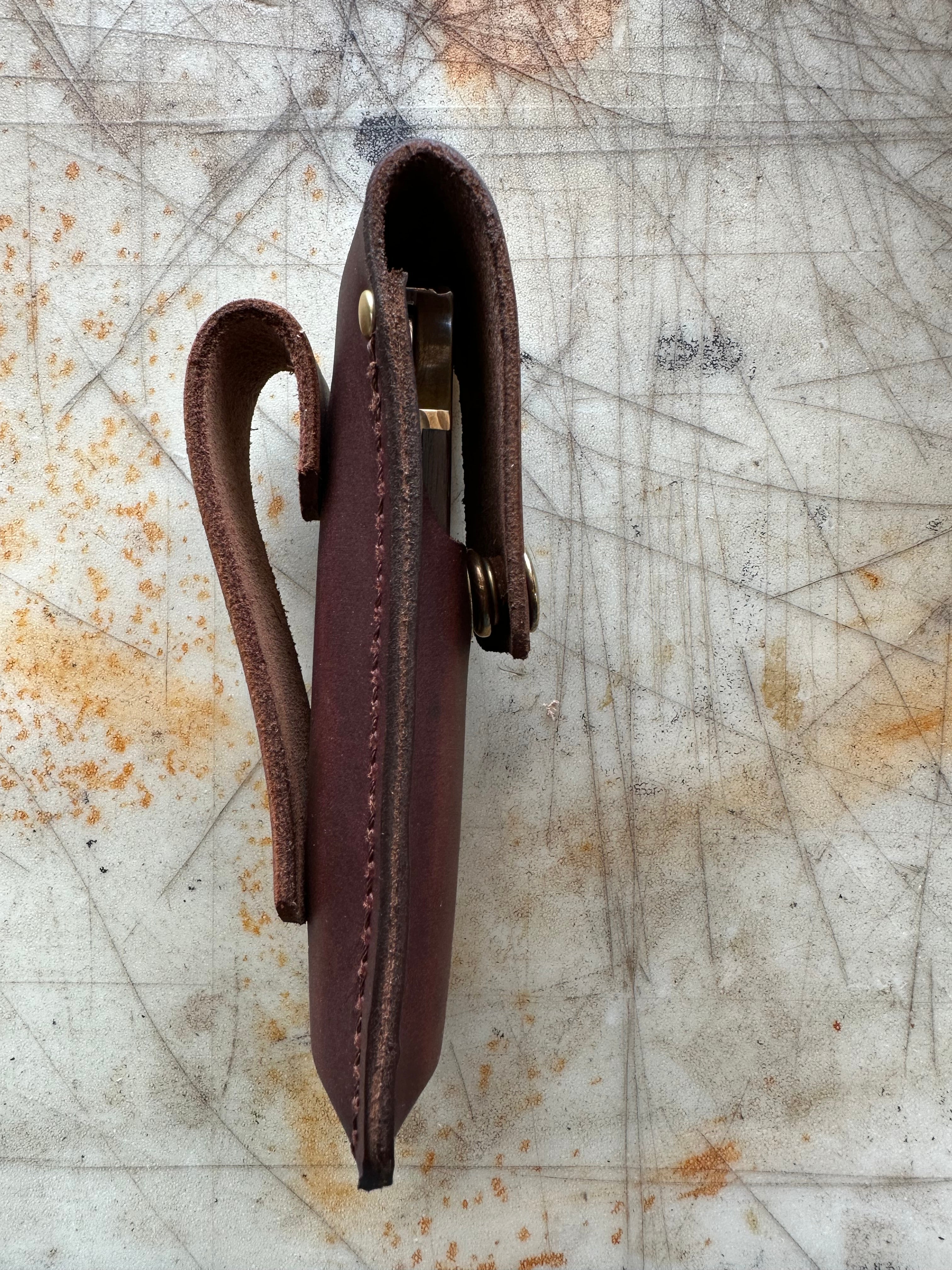 Brown leather knife sheath side profile on a textured surface