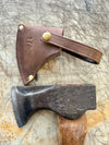 Axes with leather sheaths on a textured surface