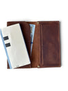 An open brown leather bifold wallet with card slots, a cash compartment, and a slip pocket, shown on a white background with a white envelope and cash inserted.