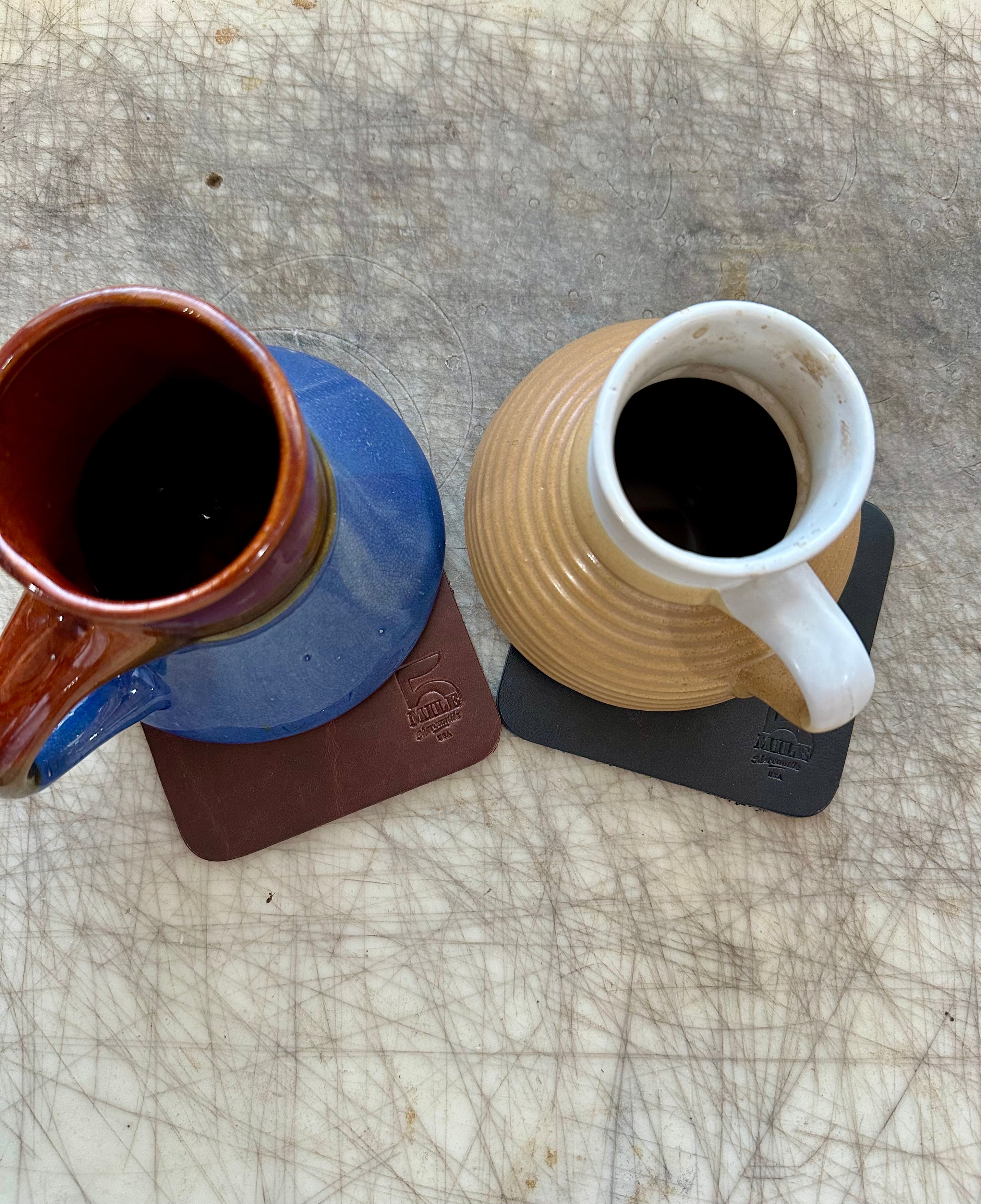 Coasters with mugs on cutting table
