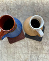 Coasters with mugs on cutting table
