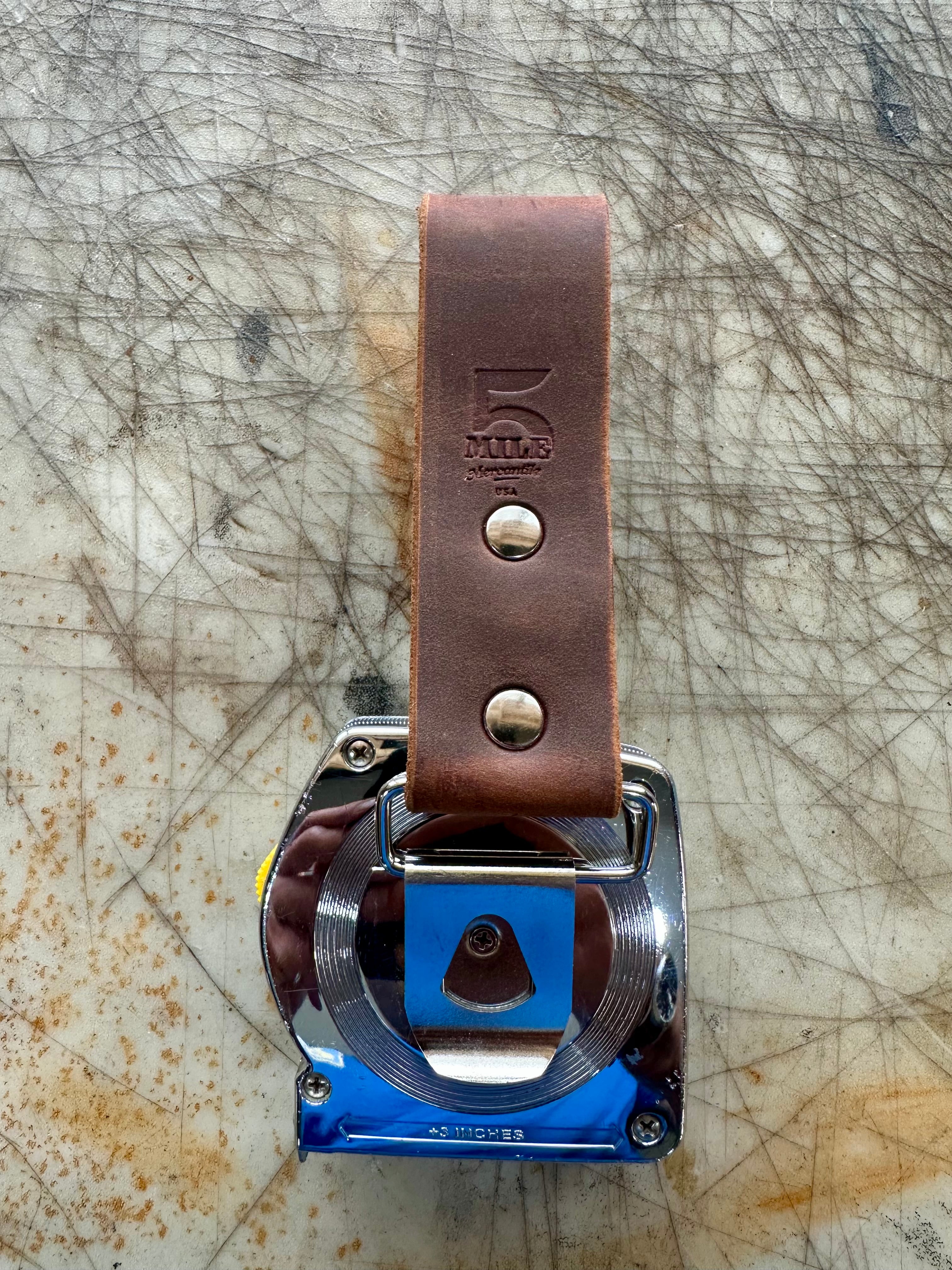 DIYer measuring tape holder with measuring on cutting table