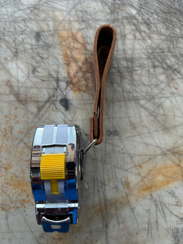 DIYer measuring tape holder with measuring table side profile on cutting table