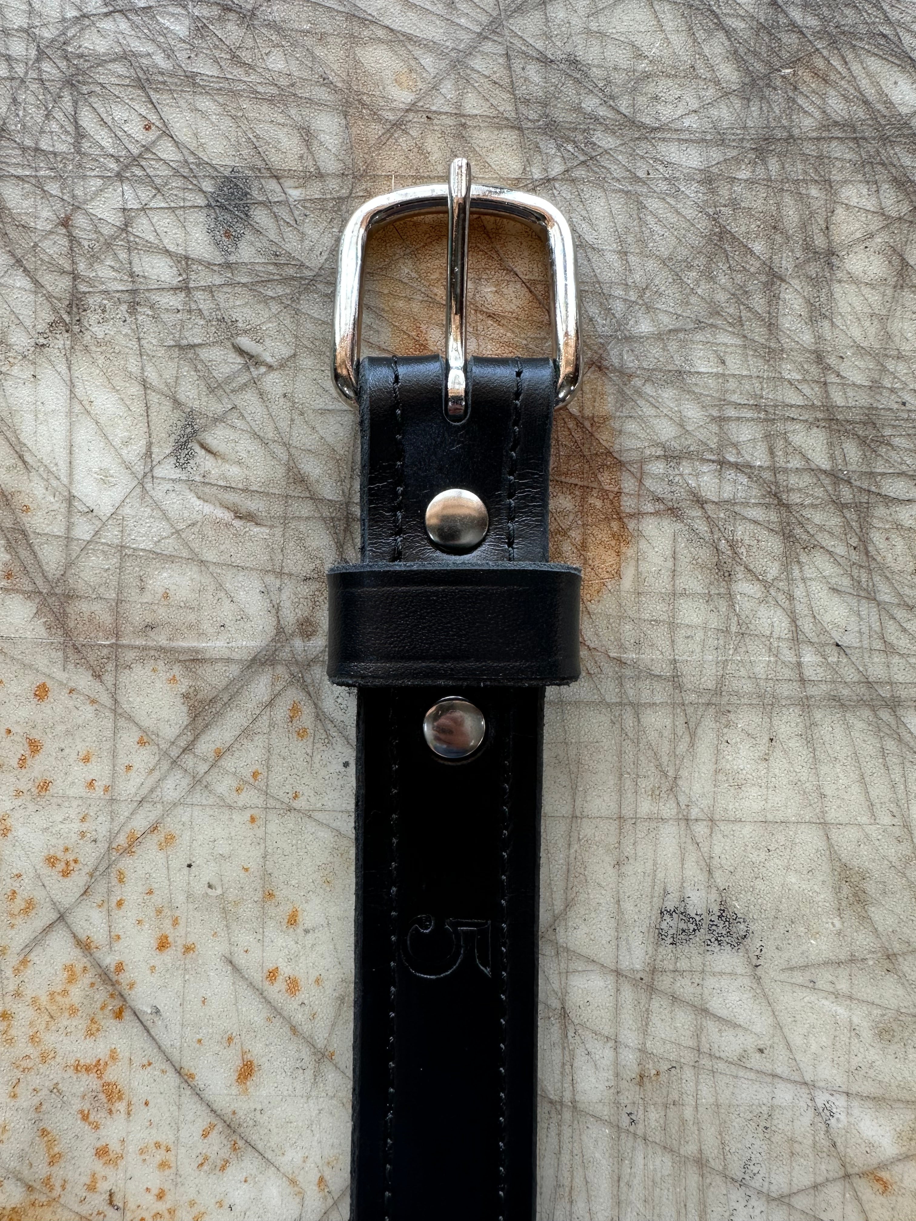 Black belt with silver buckle on textured surface