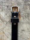 Black belt with silver buckle on textured surface