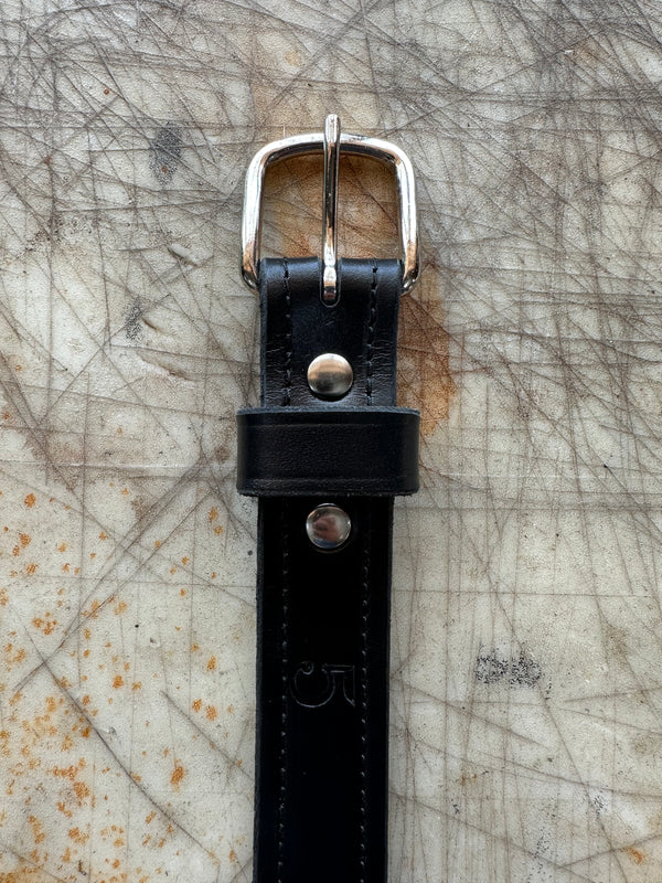 Black belt with silver buckle on textured surface