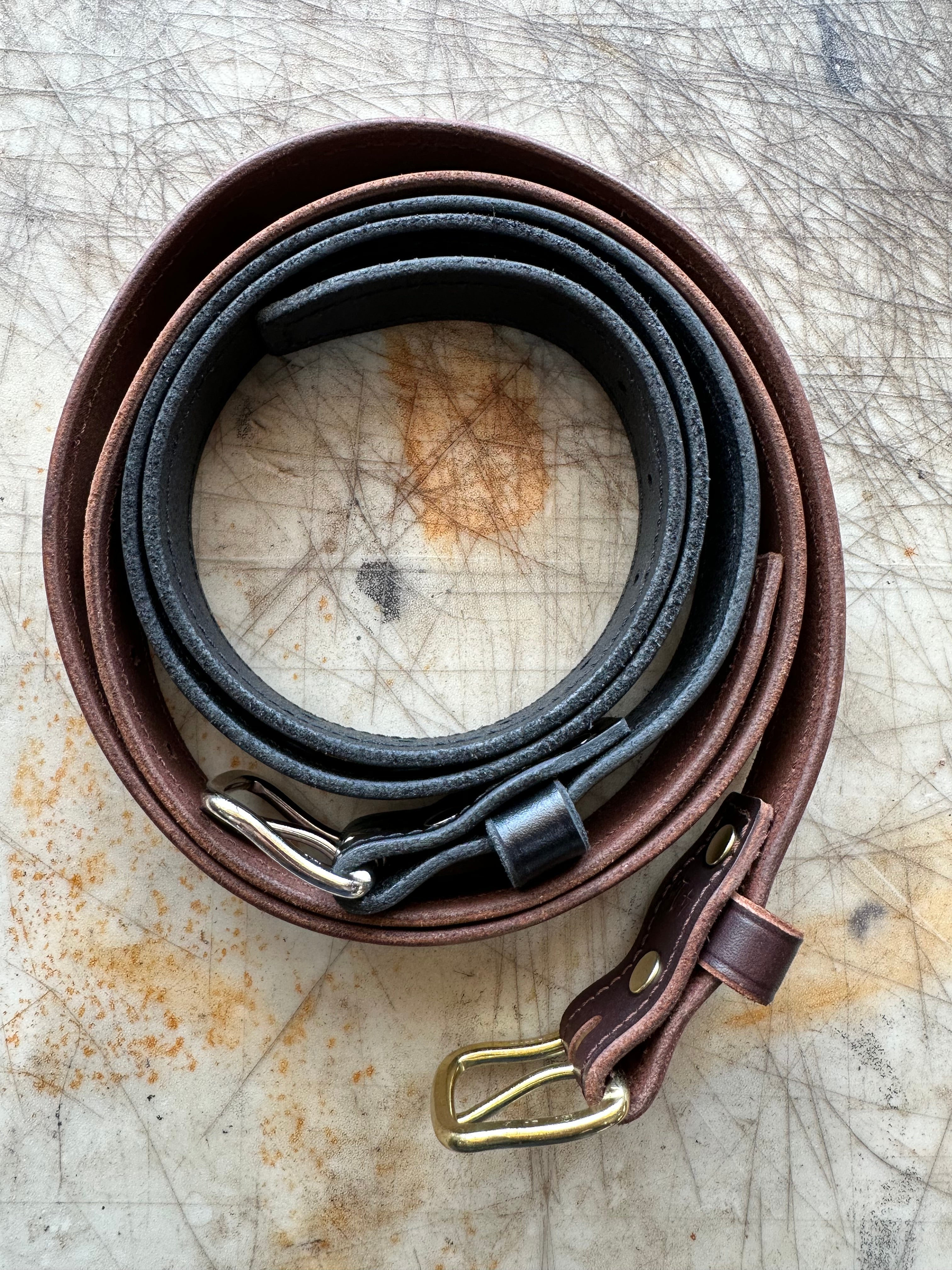 Set of leather straps with buckles on a textured surface