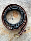 Set of leather straps with buckles on a textured surface
