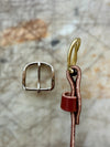 Metal buckle and leather strap on a textured stone background