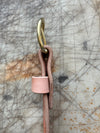 Pink leather strap on a textured surface