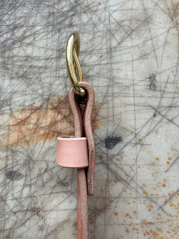Pink leather strap on a textured surface
