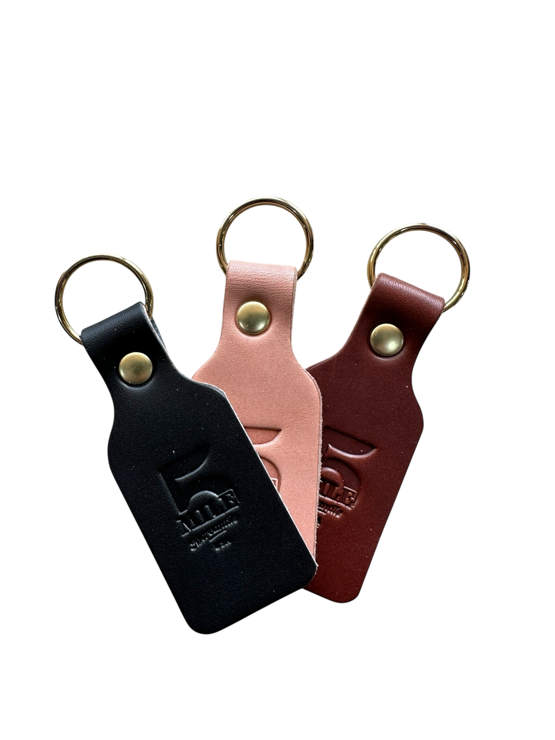 Three leather keychains in black, pink, and brown on a white background