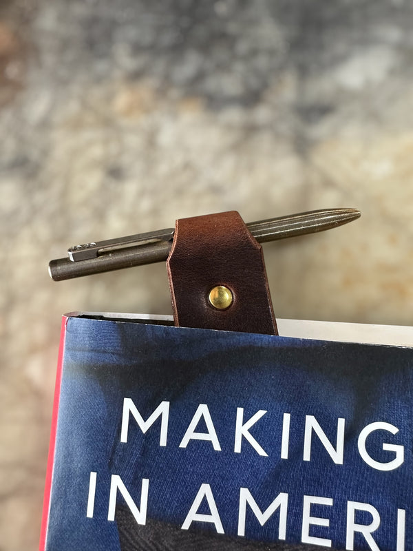 Pen with leather holder on a book titled 'Making in America' against a blurred background