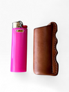 Pink bic lighter next to leather sheath