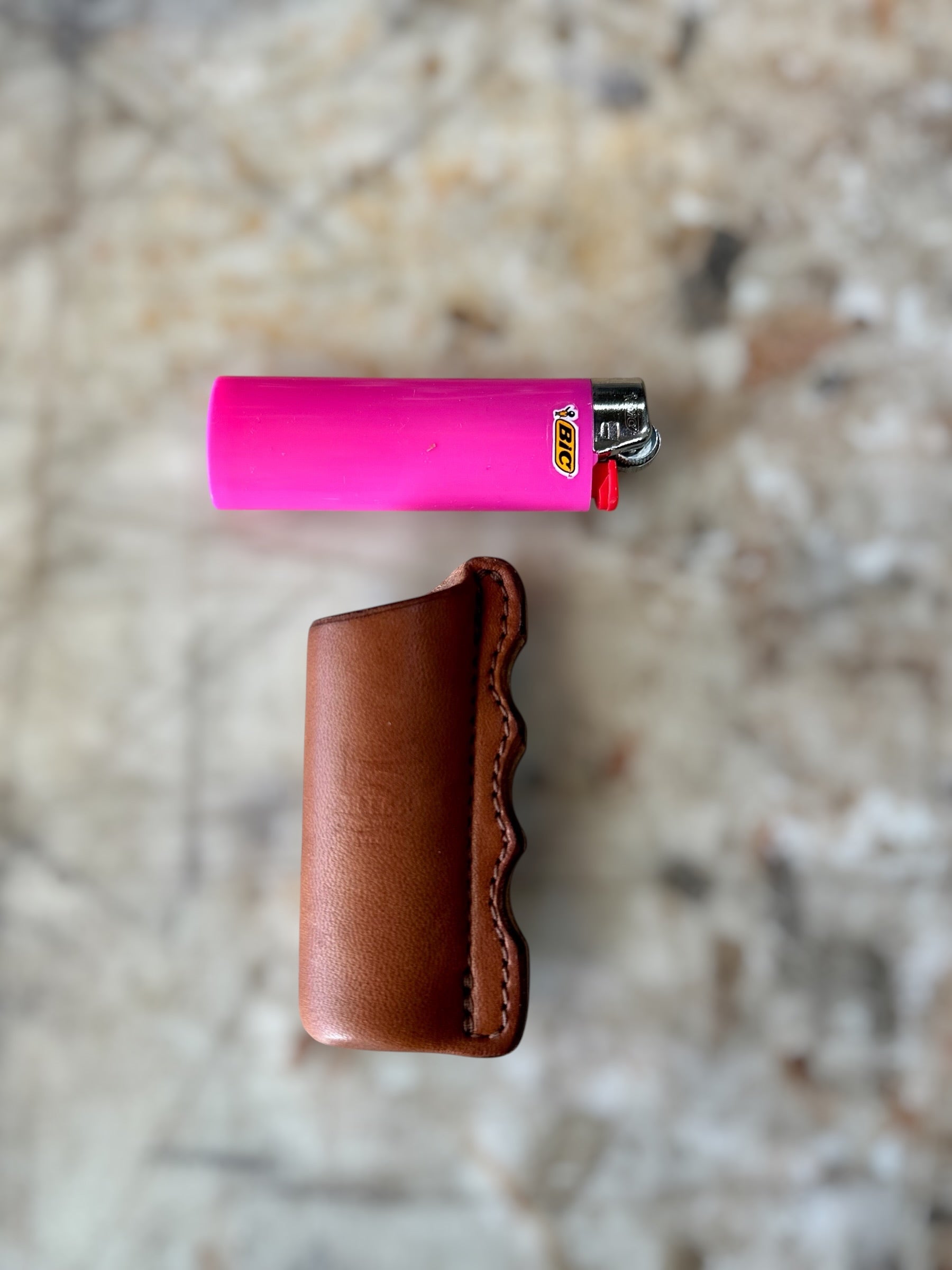 Bic lighter on cutting table above leather lighter sheath