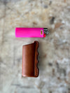 Bic lighter on cutting table above leather lighter sheath