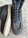 Pair of leather boots with a worn-out sole on a textured surface