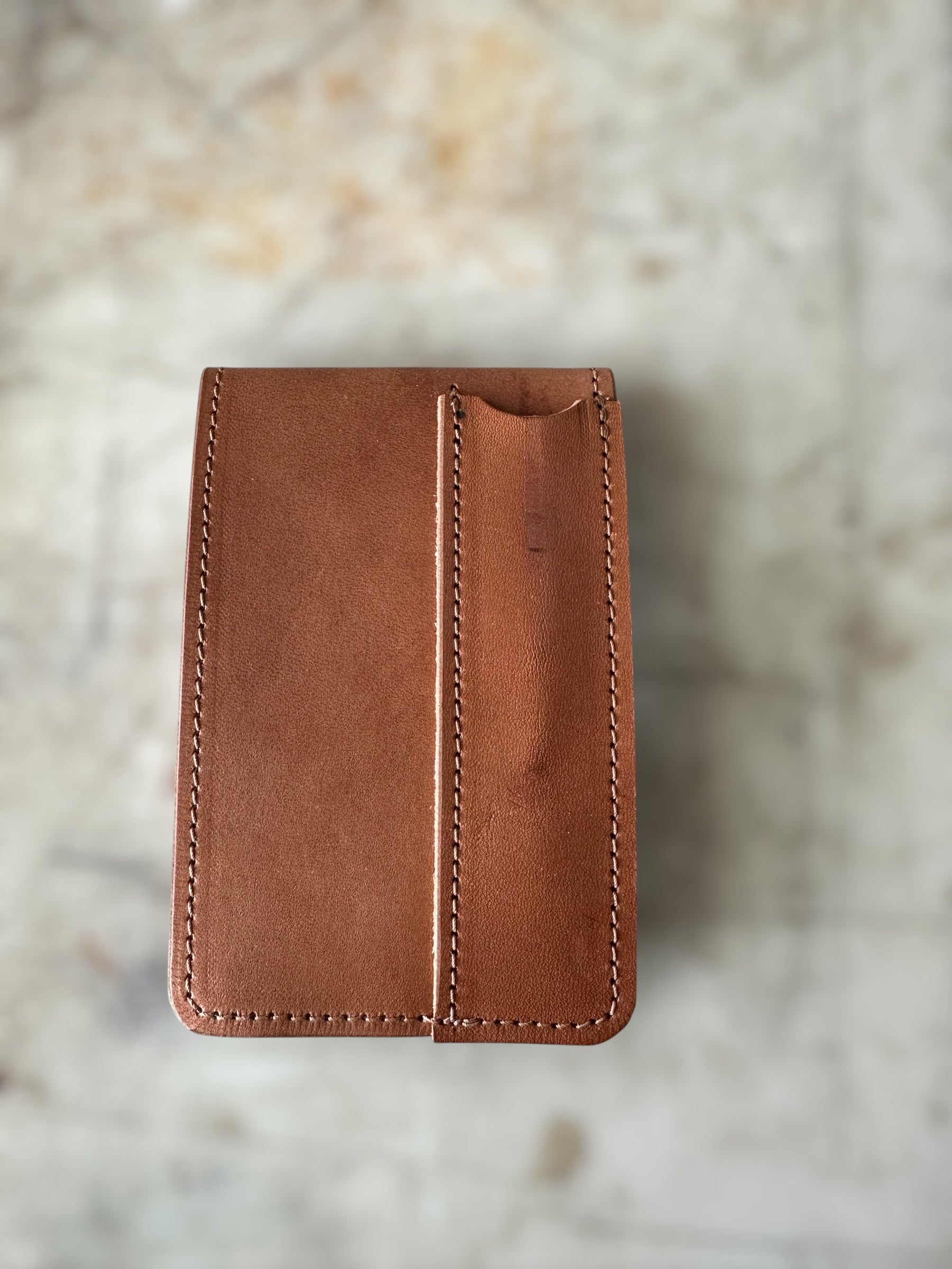 Brown leather wallet on a textured surface