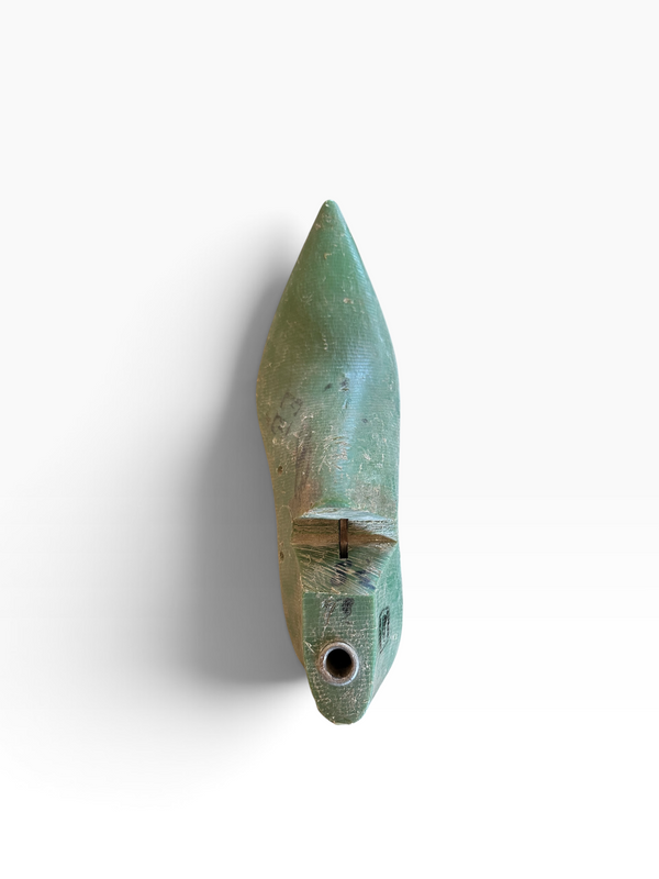 A small pointed green ceramic object with a hole near the bottom, photographed against a plain white background.