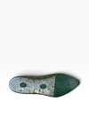 The outsole of a vintage green shoe, showing a weathered silver-toned metal plate with two circular cutouts and a dark green rubber tip, photographed on a white background.