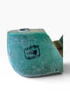 A close-up of a carved wooden pipe head with a turquoise-green finish and a black stamp reading 'MONT BLANC', set against a plain white background.