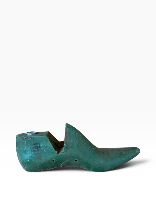 A vintage teal-green wooden shoe tree with a weathered, patinated finish, shown in profile against a plain white background.