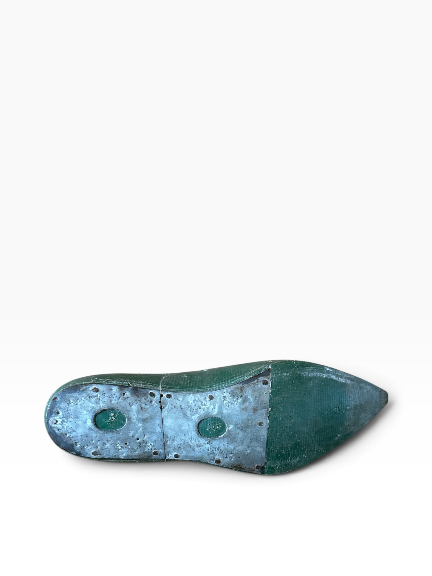 A single vintage pointed-toe shoe shown from the sole side, featuring a distressed teal and metallic silver-blue finish with two circular green accents, set against a plain white background.