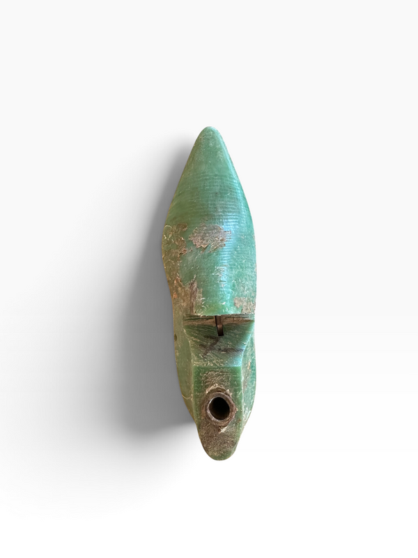 An antique-style green ceramic pipe or wind instrument with a weathered patina, shown against a plain white background.