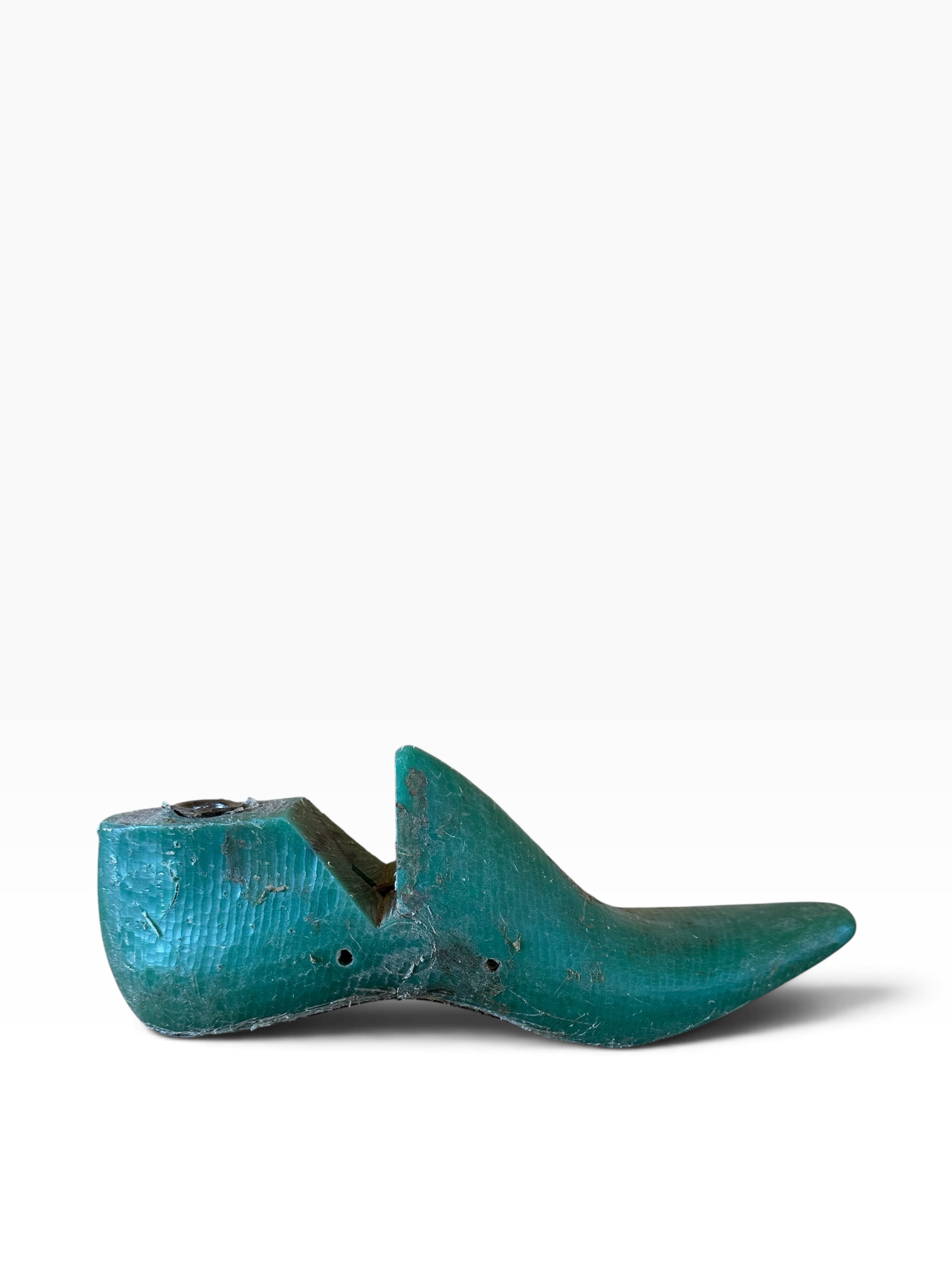 A vintage wooden shoe tree with a distressed teal-green patina, shown in profile against a clean white background.