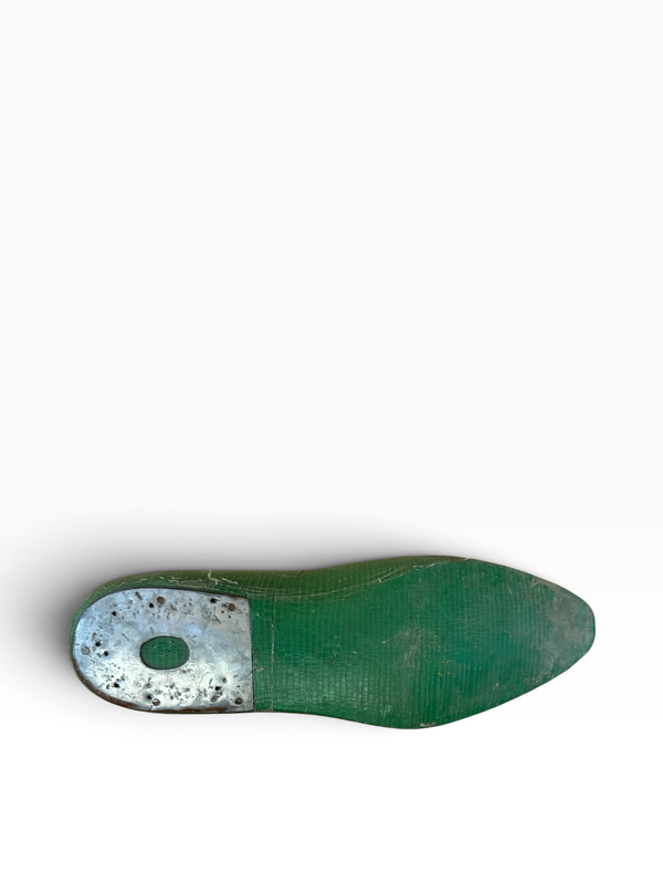 A single green shoe sole viewed from above against a plain white background.