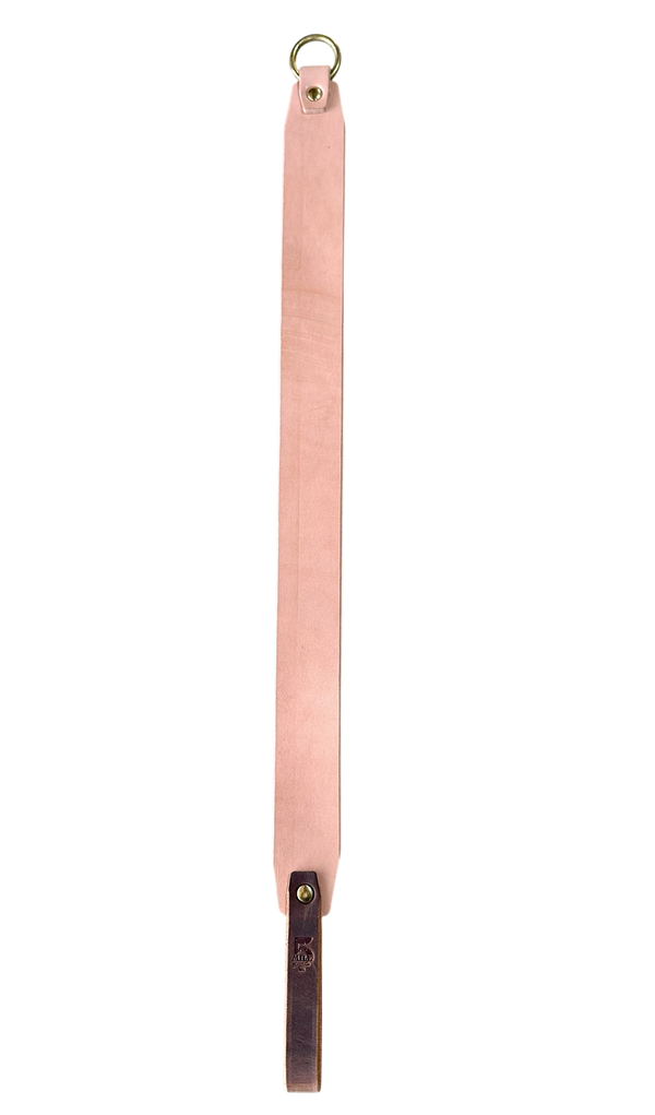 Pink leather strap with a gold ring on a white background